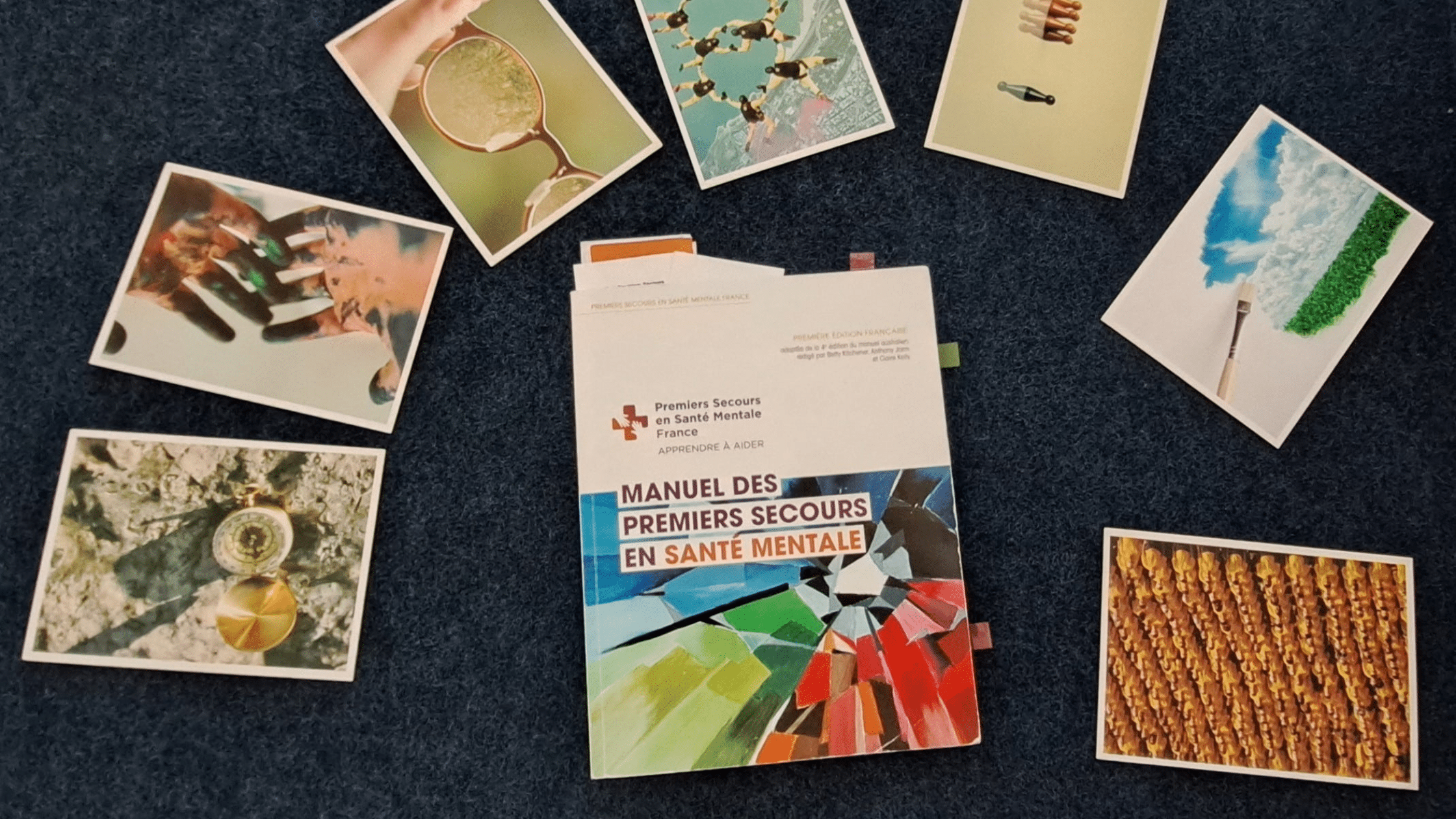 Manuel des Premiers Secours en Santé Mentale entouré de cartes illustrées utilisées lors d'une formation